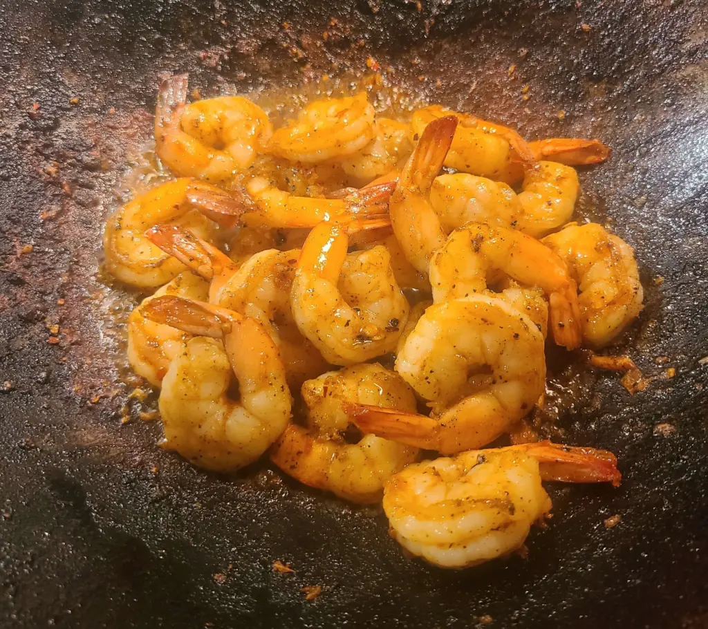 The shrimp are shown in the wok, having just completed the cooking process.