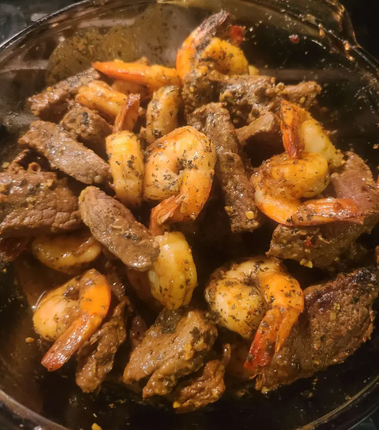 Thai basil has been added to the beef shrimp mixture, and the bowl has been tossed to blend the spices together with the meat and combine the two ingredients into a harmonious whole.